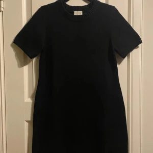 Svart stickad klänning från H&M! Oanvänd! Ny! - Snygg svart stickad klänning med korta ärmar och rund halsringning. Perfekt för en stilren look. Klänningen har en enkel design som gör den lätt att matcha med olika accessoarer. endast använd vid ett tillfälle! Mycket bra skick. Slutsåld på H&M. 