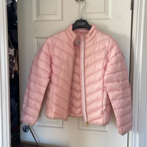 Ljusrosa pufferjacka Hampton Republic - Säljer en ljusrosa pufferjacka från Hampton Republic med quiltad design och coolt badge på ärmen. Jackan har dragkedja framtill och står ut med sin mjuka, fluffiga känsla. Perfekt för dig som vill ha en snygg och bekväm jacka till kyligare dagar.