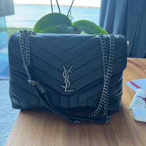 Saint Laurent väska - Svart saint Laurent väska, osäker om äkta därav pris 