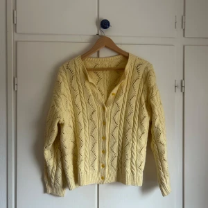 Gul kofta  - En jättefin ljusgul kabelvirkad kofta. Skulle säga i storlek S.