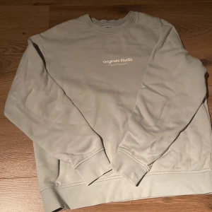 Ljus mintgrön sweatshirt från Jack & Jones - Snygg ljus mintgrön sweatshirt från Jack & Jones Originals Studio med tryck på bröstet. Klassisk rund halsringning och långa ärmar. Tillverkad i mjuk bomullsmix som är skön att ha på sig. Perfekt för en chill och stilren look.