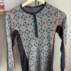 Underställ Kari Traa - Snygg långärmad ulltröja från Kari Traa med grått och vitt nordiskt mönster. Superskön och passar till lager-på-lager-stil. Lagat två hål men det är absolut inget som märks av.