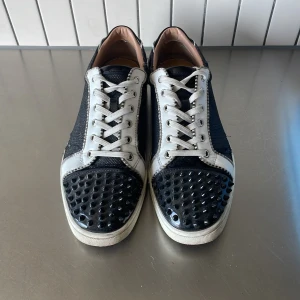 Louboutins - Vi säljer dessa svarta Christian Louboutins med vita och silvriga detaljer. De är i storlek 44 men passar även lite mindre. Pris kan diskuteras vid snabb affär. Hör av dig vid funderingar!