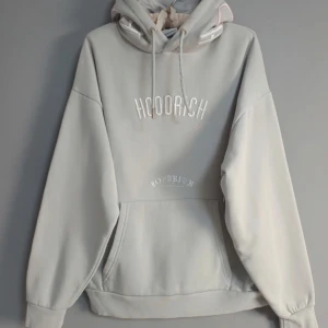 Hoodrich Ljudgrå hoodie S - Säljer en ljusgrå hoodie från Hoodrich med broderad logga på bröstet och magficka. Tröjan har huva med snörning och ribbade muddar vid ärmslut och nederkant. Perfekt för en chill och avslappnad stil.