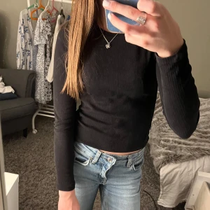 Svart ribbad långärmad tröja - Säljer en svart, ribbad långärmad tröja med rund halsringning!🤗Tröjan är i stretchigt material och har en tight passform!! Den har även lite detaljer vid axlarna för piffar upp den lite!! Perfekt att matcha med jeans eller kjol på de varm/kalla dagarna!!☺️Hör av er om ni har frågor eller vill ha fler bilder/mått!!🥰