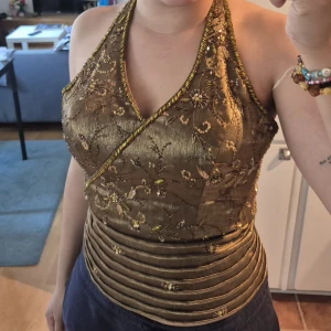 Vintage beaded  fairy top/corset - Unique golden corset top with embroidered flowers and pearls, wrap-around cut and halterneck. Thick waistband with pleated details and glittery sequins. Perfect for those who want to stand out with a luxurious and detailed look.                                           I would say size M-S as you can tie it yourself how tight you want it.