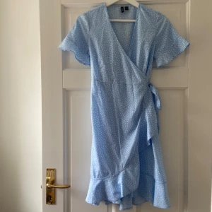 Säljer en jättefin kort blå/vit prickig klänning med volanger - Jättesnygg klänning med fina detaljer, den har en superfin design med rosetten och volangerna, den är perfekt nu till sommarens speciella tillställningar🌸Den är ifrån Vero Moda i storlek xs, är i väldigt bra skick,knappt använd, är jätte skön och sval, har bra passform, är enkel att styla och är i så bra material/kvalitet⭐️ Den är ljusblå och har vita fina prickar på med en fin rosett på sidan👍🏻skriv om funderingar, lämna gärna omdömen om köpt och priset kan diskuteras😊