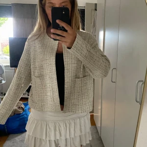 Beige rutig overshirt med fickor - Säljer en beige overshirt med rutigt mönster och två stora fickor framtill. Jackan har rak passform, lång ärm och är öppen framtill utan knappar eller dragkedja. Perfekt att slänga över en topp för en chill look.