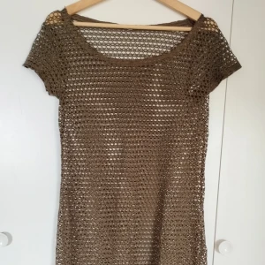 Nätklänning från Calzedonia - Säljer en brun, kort nätklänning från Calzedonia, som även funkar som beach cover-up. Den ger även en virkad vibe. Säg till om du vill ha bild på hela klänningen; Bilderna beskärs så dumt i appen.