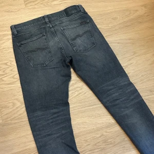 Grå Lean Dean Nudie Jeans - Tjenare! Säljer ett par mörkgrå jeans från Nudie i storlek 30/30. Jeansen sitter slim/skinny i modellen Lean Dean. Riktigt snygg tvätt och bra passform. Hör av er vid fler frågor!