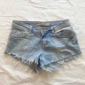 Ljusblå lågmidjade jeansshorts från Denim Co. - Säljer ett par snygga blå jeansshorts från Denim Co. med slitna detaljer och fransiga kanter. Midjemåttet är cirka 74cm. Passar xs/s💗 priset går att diskuteras
