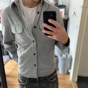 Grå overshirt från H&M - Snygg grå overshirt från H&M, Nästan aldrig använt så skicket är 10/10. Den kostade nypris 450kr