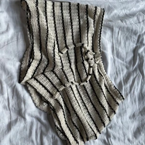 Randiga shorts från Gina Tricot - Snygga stickade shorts från Gina Tricot i beige och svart med horisontella ränder. De har en loose passform och knytband i midjan. Perfekta för sommarens chill dagar eller strandhäng. Mjukt och luftigt material som känns skönt mot huden.