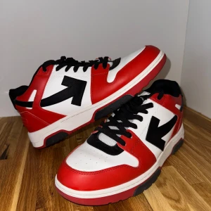 Off-White Out of Office Basket sneakers - Snygga sneakers från Off-White i rött, vitt och svart med den ikoniska pilen på sidan. Skorna har svart snörning, rund tå och platt sula. Perfekta för dig som vill sticka ut med streetstyle och cool design.