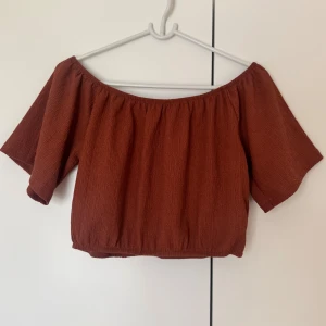 Roströd offshoulder topp - Superfin topp i roströd / rosbrunt med offshoulder-modell och korta ärmar. Tunt, lätt skrynklat tyg. Jättefint skick! 