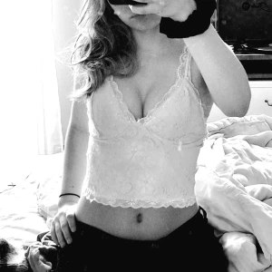 Vit spetslinne - Säljer mitt fina, vita spetslinne med justerbara axelband och blommigt mönster. Toppen har en elegant design med spetsdetaljer och en elastisk rygg för bättre passform.