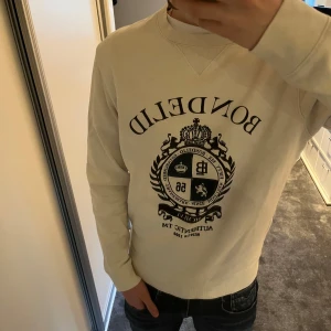 Vit sweatshirt från Bondelid - Säljer en stilren vit sweatshirt från Bondelid med ett Skit snyggt tryck som ger lite old money känsla och är Perfekt för en avslappnad stil. Skick är som nytt iprensip och Nypris är 750kr, skriv vid minsta lilla fundering😉