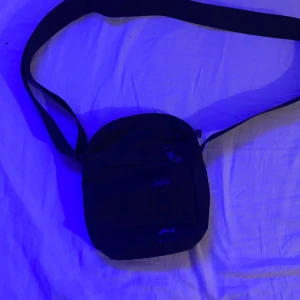 Svart axelväska från Björn Borg - Säljer en stilren svart axelväska från Björn Borg. Väskan har en praktisk dragkedja framtill och justerbar axelrem. Perfekt för att bära med sig det nödvändigaste på språng.