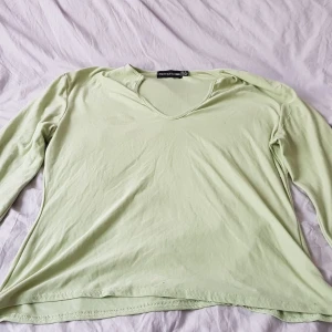 Ljusgrön långärmad topp från PrettyLittleThing - Säljer en ljusgrön långärmad topp från PrettyLittleThing. Toppen har en v-ringad hals och är tillverkad i ett mjukt material. Perfekt för en avslappnad stil. 💚
