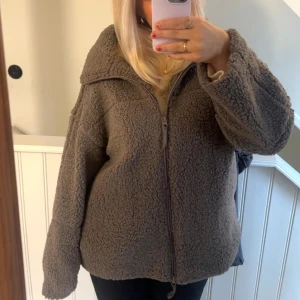 Grå teddyjacka med dragkedja - Säljer min Teddy jacka för den är förstor den har bara används en gång så helt ny. I storleken M från Gina tricot 