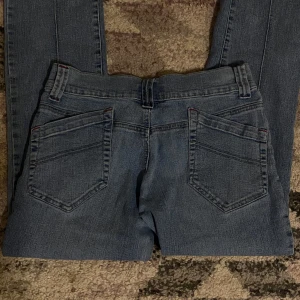 Blå jeans från Nutshell - Snygga blå jeans från Nutshell med klassisk femficksdesign och knappstängning. De har en rak passform och är perfekta för en avslappnad stil. Jeansen är tillverkade i ett slitstarkt material som ger en bekväm känsla hela dagen.