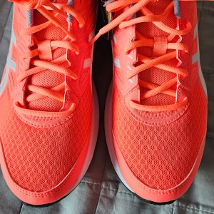 Asics Jolt 3 i korall och vit - Snygga och sportiga Asics Jolt 3 sneakers i en iögonfallande korallfärg med vita detaljer. Skorna har en bekväm passform och är perfekta för träning. De har snörning och en slitstark sula för bra grepp. Ngt små i storleken. 