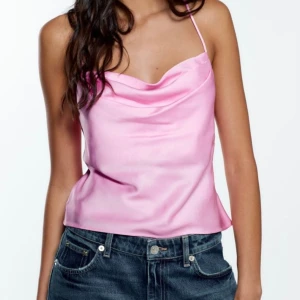 Rosa satinlinne - Säljer ett snyggt rosa satinlinne med tunna axelband och en draperad halslinje. Perfekt för en somrig look eller en utekväll. Passar bra med jeans eller kjol för en stilren outfit.