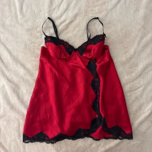 Röd topp med svarta spetsdetaljer - Säljer en röd topp med svarta spetsdetaljer. Bygeln har gått upp men går att lätt att fixa 🌸