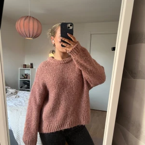 Rosa stickad tröja - Mysig rosa stickad tröja med en avslappnad passform. Perfekt för kyliga dagar med långa ärmar och ribbade muddar. En härlig baströja för garderoben.