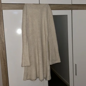 Beige stickad klänning - Mysig beige stickad klänning med lång ärm. Perfekt för kyligare dagar med sin mjuka och bekväma passform. Enkel och stilren design som passar till många tillfällen. Ordinarie pris är 500kr. Köpte den precis men den va inte för mig. 