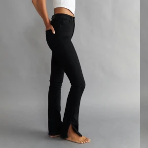 Svarta högmidjade jeans petite - Snygga svarta högmidjade jeans med en tight passform. Byxorna har slits nertill och är i petite. 