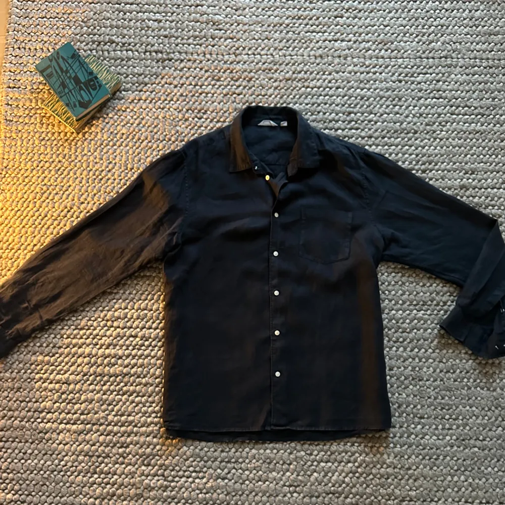 Snygg svart skjorta från Dobber med klassisk krage och knappar framtill. Perfekt för en stilren look. Skjortan har en bröstficka och perfekt passform. Ett utmärkt val inför vår och sommaren! . Paidat.