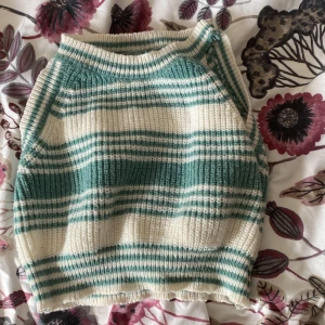 Linne Randig stickad ärmlös topp  - Säljer en mysig stickad topp i grönt och vitt med randigt mönster. Toppen är ärmlös och har en ribbad struktur som ger en skön passform. Perfekt för lager-på-lager-stil eller att bära som den är. Hör av dig vid intresse! 🌿