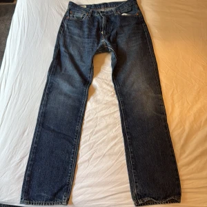 Levi's 551Z raka jeans W30 L34 - Klassiska blå Levi's 551Z jeans med rak passform och fem fickor. Jeansen har dragkedja och är tillverkade i slitstarkt denim. Perfekta för dig som gillar en tidlös och avslappnad stil.