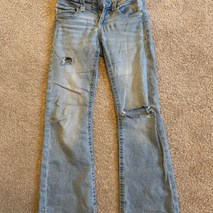 Ett par jeans från Gina tricot  - Jag säljer ett par ljusblåa jeans från Gina tricot . Dom har två hål på framsidan av jeansen. 