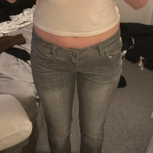 Grå jeans från ONLY - Säljer ett par grå jeans från ONLY med låg midja. Jeansen har en rak fast mer utsvängd passform i benen, jeansen går inte att köpa mer. Ny pris 750kr. Kan gå ner i pris vid snabb affär