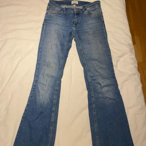 Blå bootcut jeans från ONLY - Säljer ett par blå Low waist  bootcut jeans från ONLY. Det är storlek 32 i onlys egen storlek vilket är en S i vanlig. De är även väldigt stretchiga och sköna.  Använda men inga tecken på slitage, nypris: 700 kr