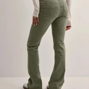 Gröna bootcut jeansbyxor - Snygga olivgröna jeansbyxor med bootcut-passform och klassiska fickor bak. Helt oanvända med prislapp kvar!! Beställde två st och hann inte lämna tillbaka dessa💝💝 Därför säljer jag vidare 