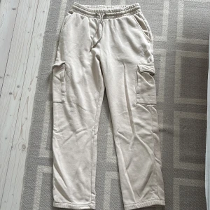 Beige mjukis - Säljer ett par beige cargobyxor från SMOG med resår och dragsko i midjan. 