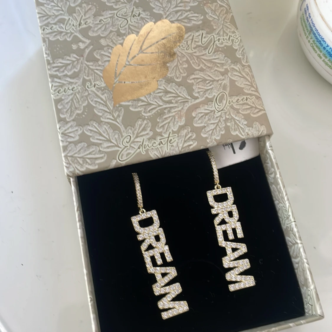 Glittriga örhängen med texten DREAM från ioauk