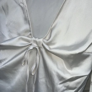 Vit långärmad omlottopp med knyt - Säljer denna jättesöta fest topp! I storlek S, men passar M också. Aldrig använd. Säljer en elegant vit långärmad topp i satinliknande material med v-ringning och knyt framtill. Toppen är perfekt för att lyfta vilken outfit som helst!💓