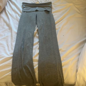 Grå mjukisbyxor från Gina Tricot - Grå mjukisbyxor från Gina Tricot med bred, vikt midja och raka, vida ben. Byxorna är tillverkade i mjukt bomullsmaterial och passar perfekt för en avslappnad stil.