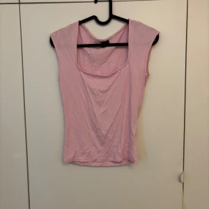 Ljusrosa topp från Gina Tricot - Säljer en ljusrosa topp från Gina Tricot med breda axelband och rundad halsringning. Toppen är ärmlös och har en enkel, stilren design som passar perfekt till sommaren. Använd 2 gånger. 