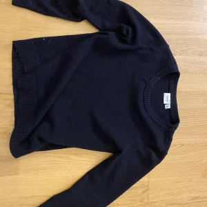 Svart stickad tröja från Vila - En klassisk svart stickad tröja  med rund halsringning och långa ärmar. Tröjan har ribbade muddar vid ärmslut, hals och nederkant. Perfekt basplagg för garderoben. Den är andvänd några gånger men är fortfarande i bra skick. Skriv om du har några funderingar! Storlek xs men sitter som s