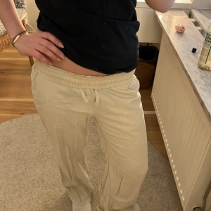 Beiga linnebyxor  - Säljer ett par beiga linnebyxor med avslappnad passform och låga i midjan. Byxorna har raka ben och är perfekta för en chill och bekväm stil. Lätta och luftiga, passar grymt till sommaren.