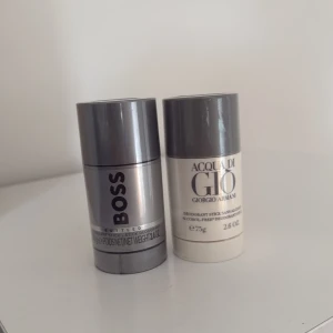 Parfymdeostick från Hugo Boss och Giorgio Armani - Två deostick: en i metallicgrå från Hugo Boss och en i ljusbeige från Giorgio Armani Acqua di Giò. Båda har rundad form och plastmaterial, 75 ml respektive 75 g. Klassiska dofter för herr. Helt oöppnad, kommer i plast. Köpt i flygplats. 200 för båda