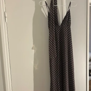 Brun prickig långklänning med knytband - Brun långklänning med vita prickar och smala axelband. Scarf ingår . Oanvänd 