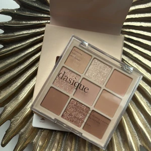 Dasique ögonskuggspalett med 9 nyanser - Ögonskuggspalett från Dasique med 9 olika nyanser i både matta och skimrande toner. Färgerna går i beige, brunt, champagne och rosé. Nypris 300