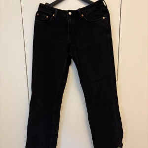 Svarta jeans Arrow Low Straight från Weekday - Säljer ett par svarta jeans från Weekday i modellen Arrow Low Straight. Jeansen har låg midja, raka ben och klassisk femficksdesign. Perfekta för dig som gillar en enkel och stilren look.