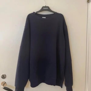 Mörkblå sweatshirt från Zara - En enkel och stilren mörkblå sweatshirt från Zara. Tröjan har rund halsringning och långa ärmar. Perfekt för en avslappnad look och passar till det mesta. Mjuk insida och ribbade muddar vid ärmslut och nederkant.